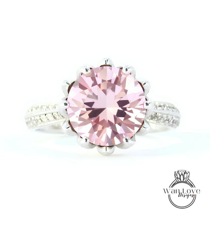 A close-up image of a beautiful pink gemstone ring with a large central gemstone surrounded by smaller stones.