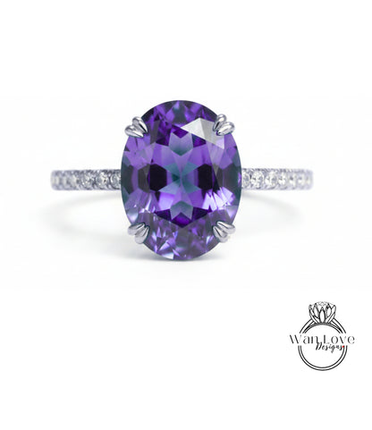 A large oval-shaped purple gemstone, possibly a sapphire or amethyst, set in a silver ring with a thin band.