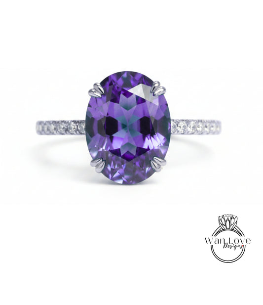 A large oval-shaped purple gemstone, possibly a sapphire or amethyst, set in a silver ring with a thin band.