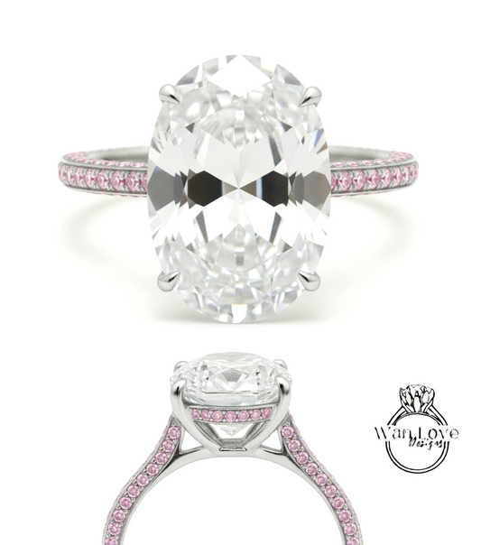 A large oval-shaped diamond engagement ring with a silver band and pink gemstones.