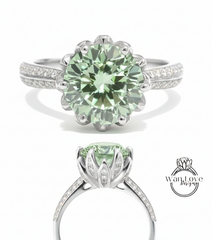 A stunning green gemstone ring with a large central stone surrounded by smaller stones, set in a silver band with a delicate flower-like design.