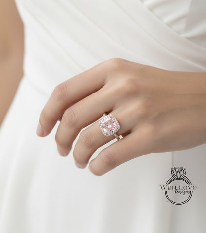 A close-up of a person's hand wearing a large, ornate ring with a pink gemstone.