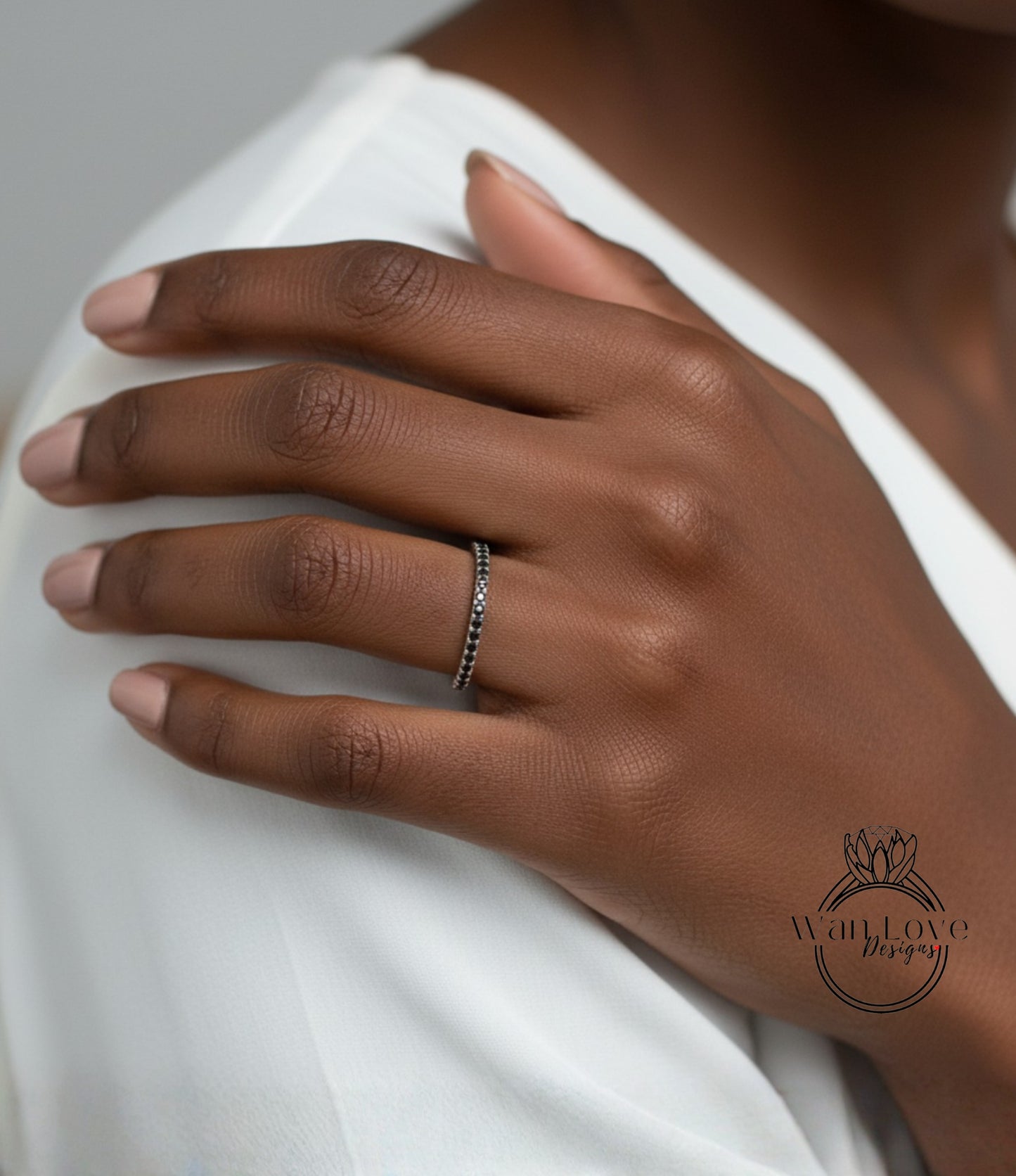 A close-up of a person's hand wearing a ring on the ring finger.