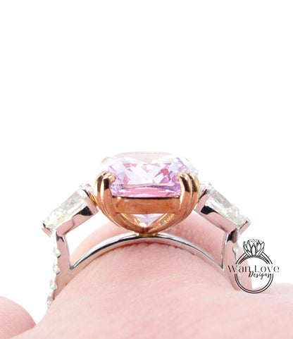 A close-up view of a person's hand wearing a ring with a large, pink gemstone.