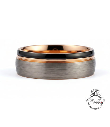 A silver ring with a black band and a thin gold band, set against a white background.