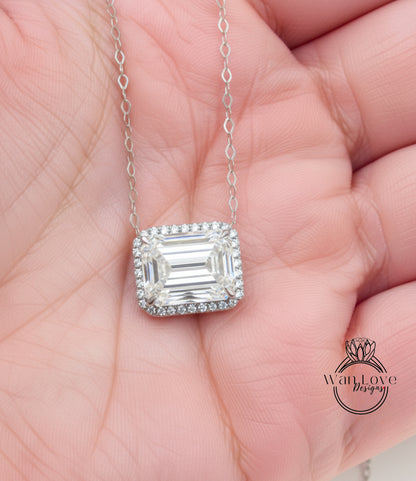A close-up image of a person's hand holding a diamond necklace with a large, clear gemstone.