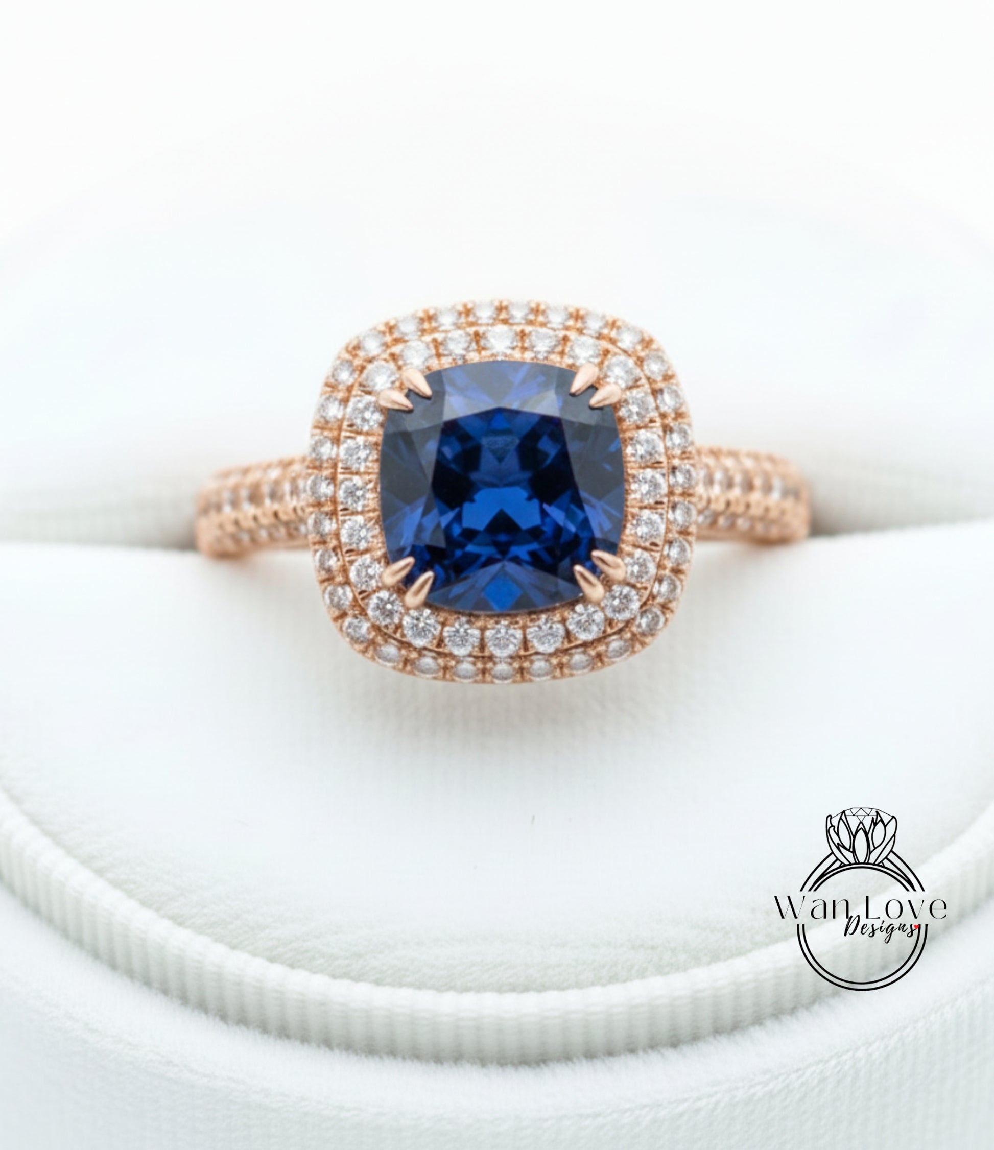 A close-up image of a gold ring with a large blue gemstone, likely a sapphire, surrounded by a halo of smaller diamonds.