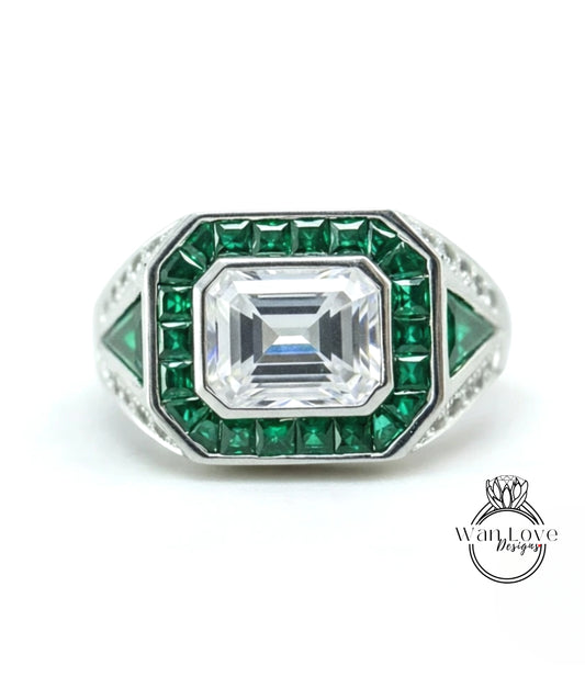 A ring with a large central diamond surrounded by smaller diamonds and green gemstones.