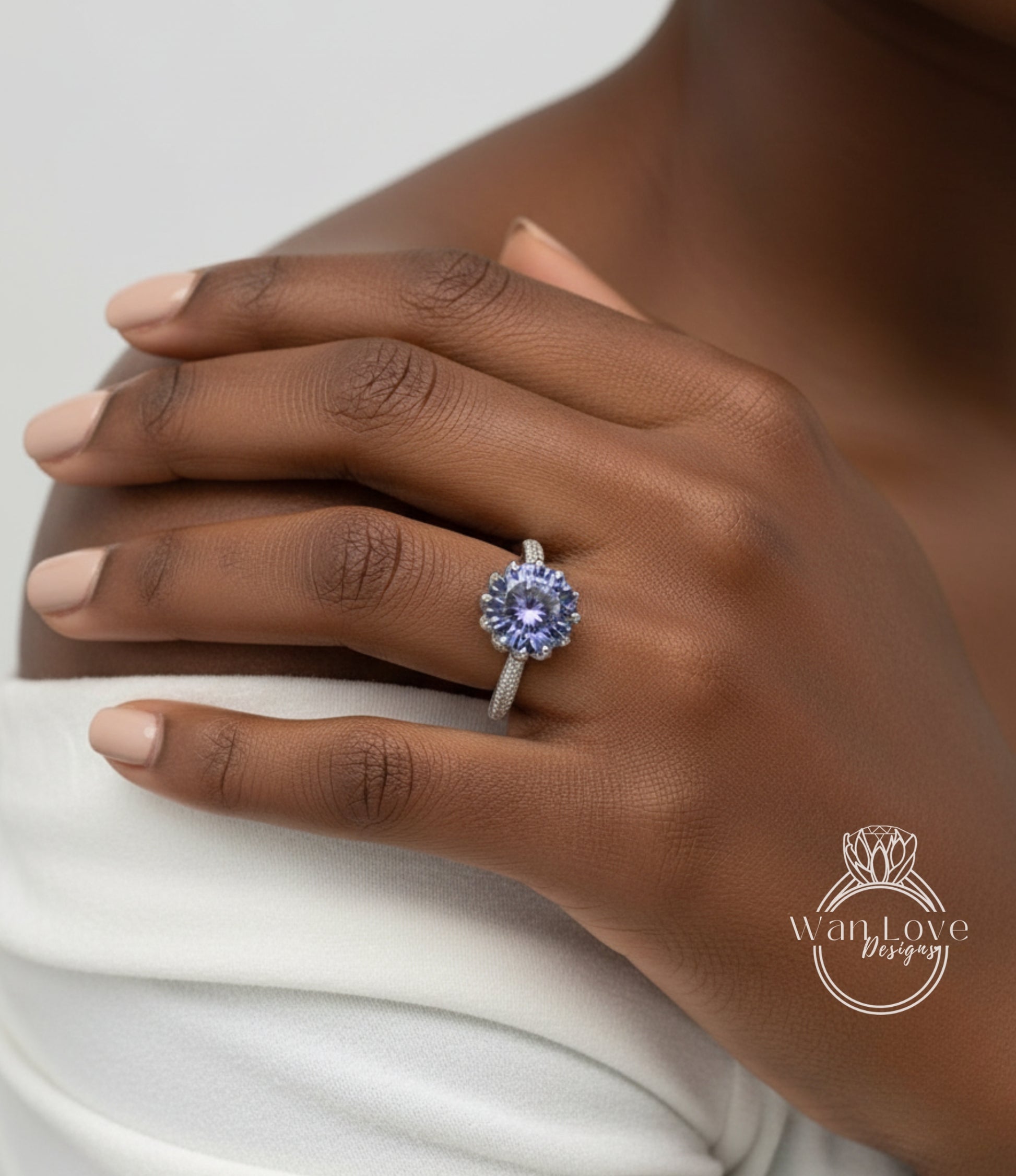 A close-up of a person's hand wearing a ring with a large, blue gemstone.