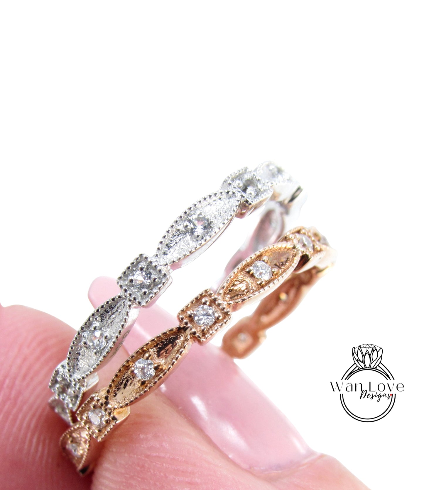 A close-up of a person's hand wearing a silver and gold ring with a row of small diamonds.