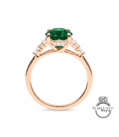 A gold ring with a large green gemstone, possibly an emerald, set in the center.