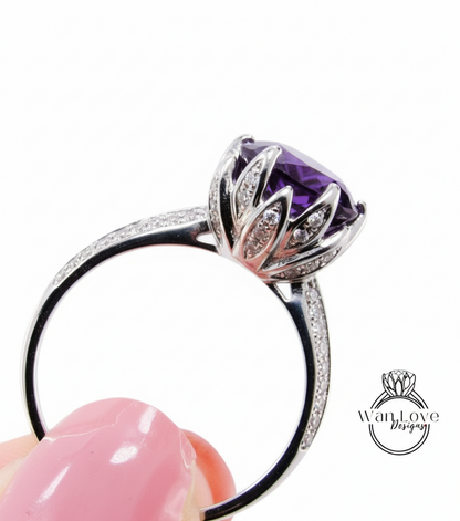 A close-up view of a silver ring with a large purple gemstone, showcasing the intricate design and sparkling gemstones.