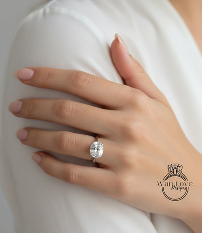 A close-up of a person's hand wearing a large diamond engagement ring.