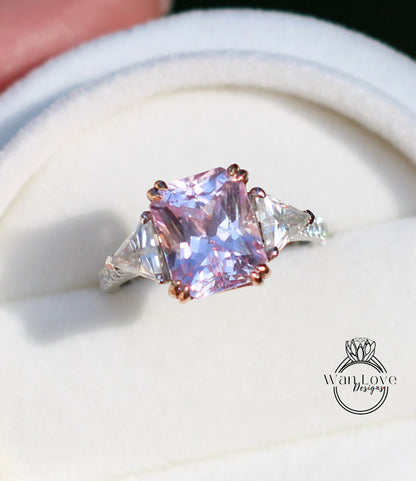 A close-up image of a pink gemstone ring with a large central gemstone surrounded by smaller triangular gemstones.