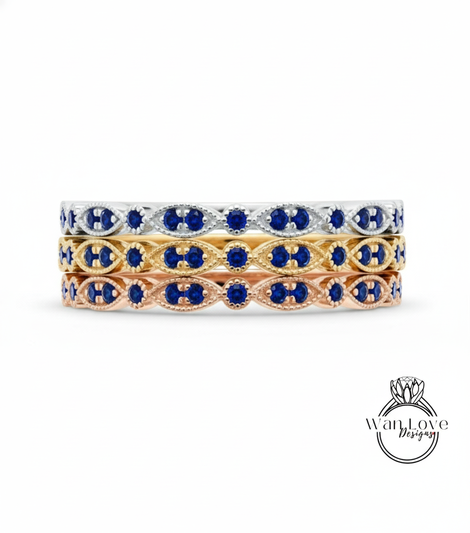 A stack of three rings with blue gemstones on a white background.