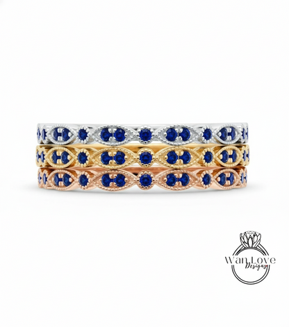 A stack of three rings with blue gemstones on a white background.