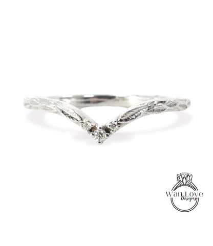 A silver ring with a leaf-like design and a small diamond in the center.