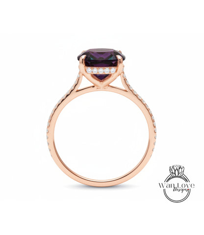 A rose gold engagement ring with a large purple gemstone set in the center, surrounded by smaller diamonds.