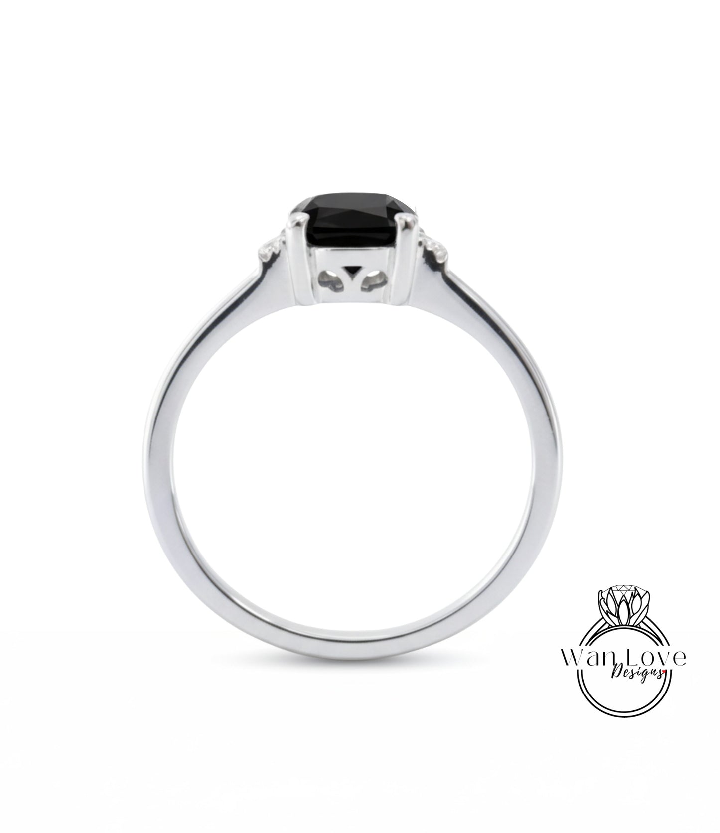 A silver ring with a black gemstone, possibly a diamond, set in the center.