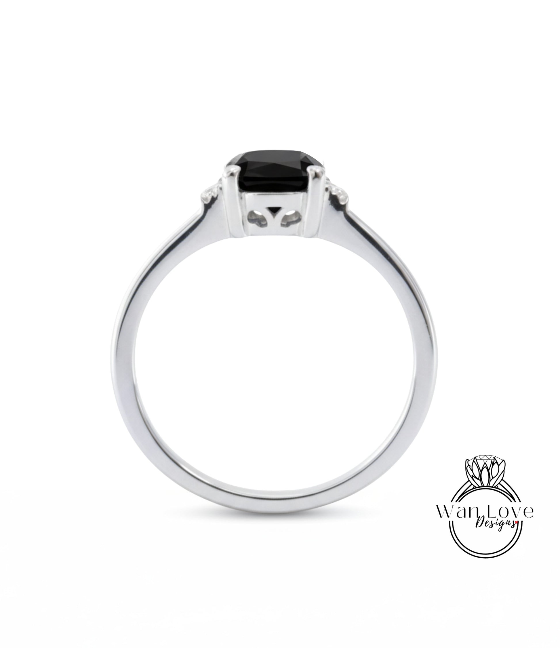 A silver ring with a black gemstone, possibly a diamond, set in the center.
