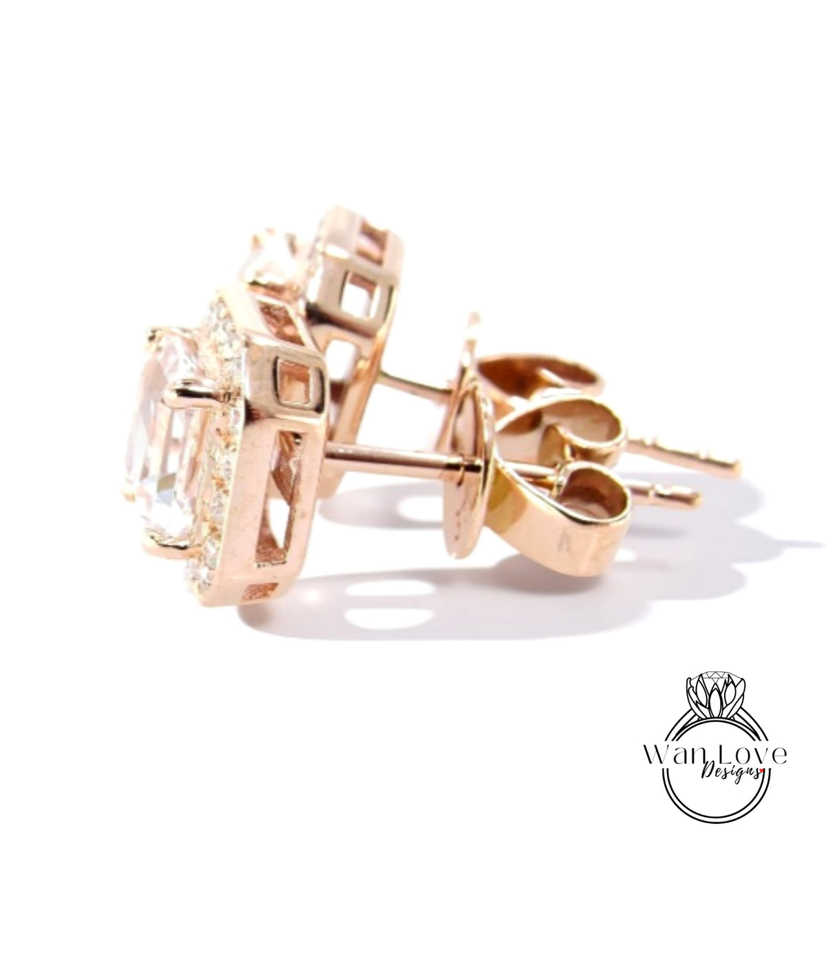 A pair of gold earrings with a clear gemstone set in the center, resting on a white background.