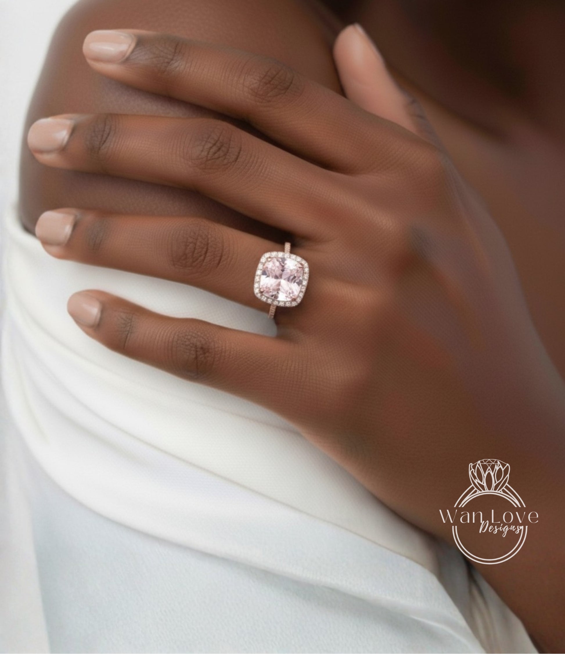 A close-up of a person's hand wearing a large, pink diamond ring on the ring finger.