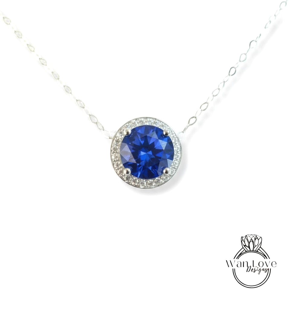 A necklace with a large blue gemstone, possibly a sapphire, surrounded by a halo of smaller diamonds.