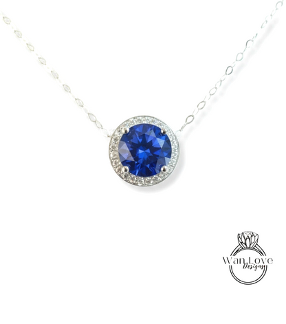 A necklace with a large blue gemstone, possibly a sapphire, surrounded by a halo of smaller diamonds.