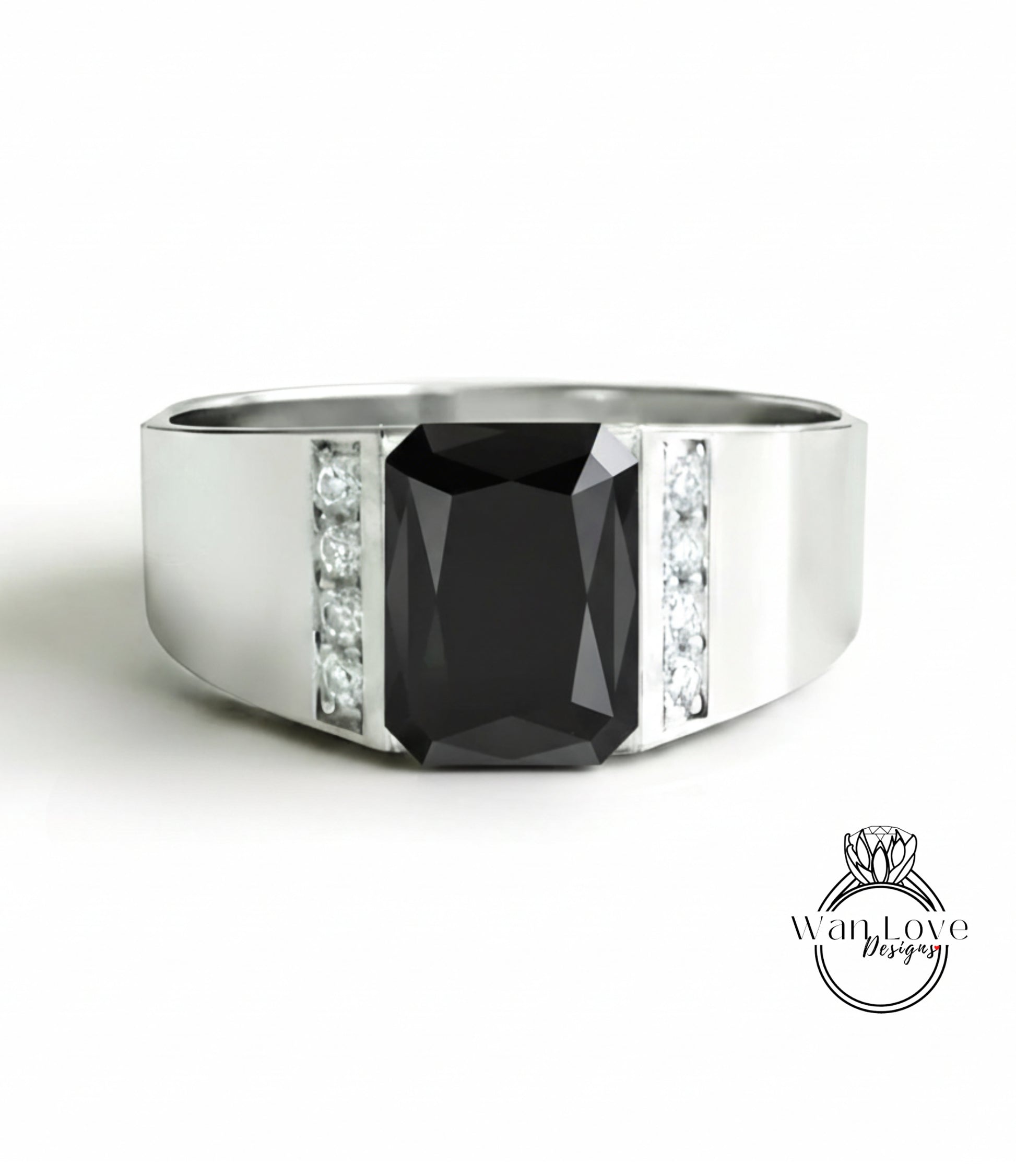 A silver ring with a large black gemstone, likely a diamond, set in the center.