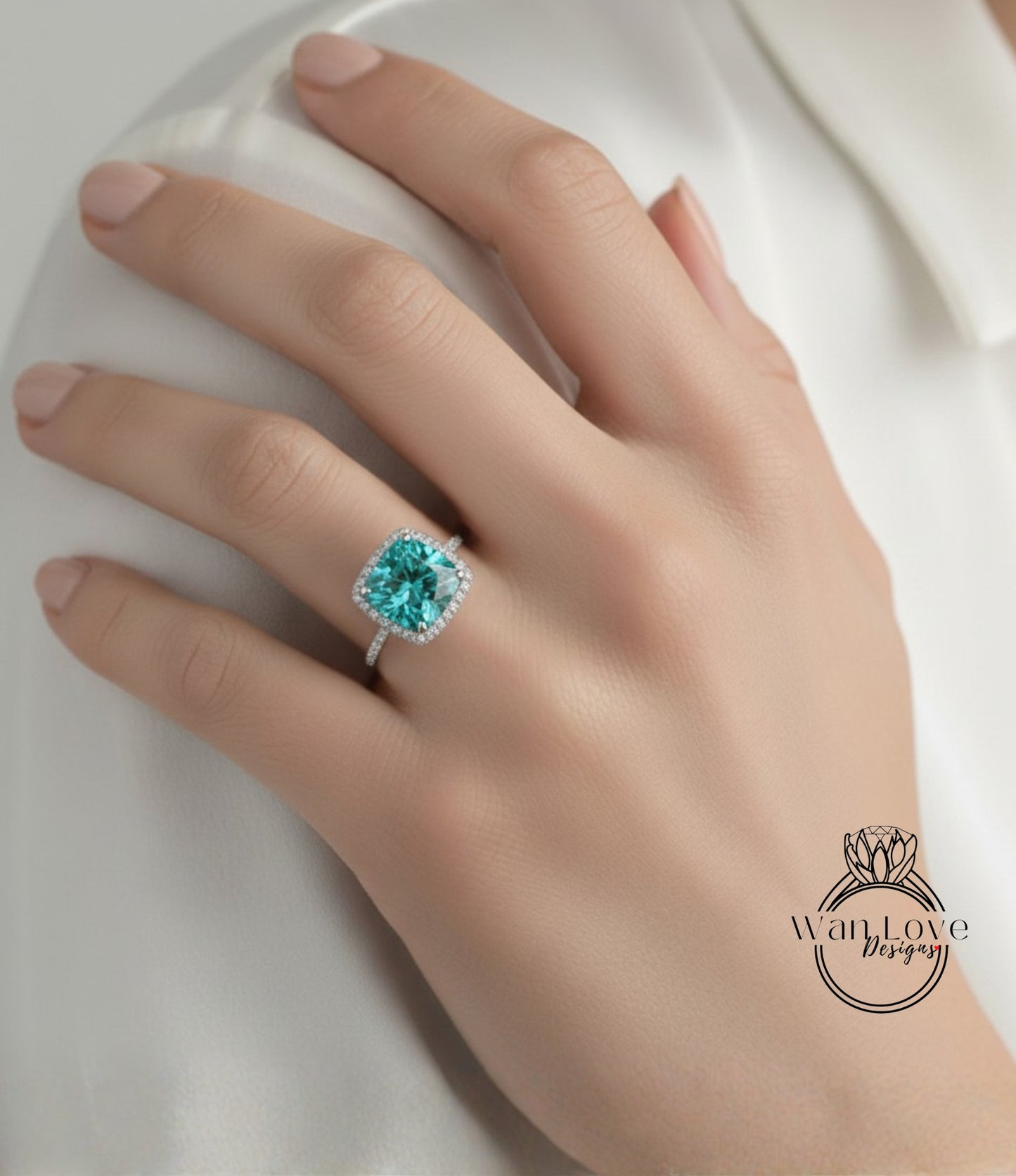 A close-up of a hand wearing a diamond ring with a large, vibrant green gemstone.