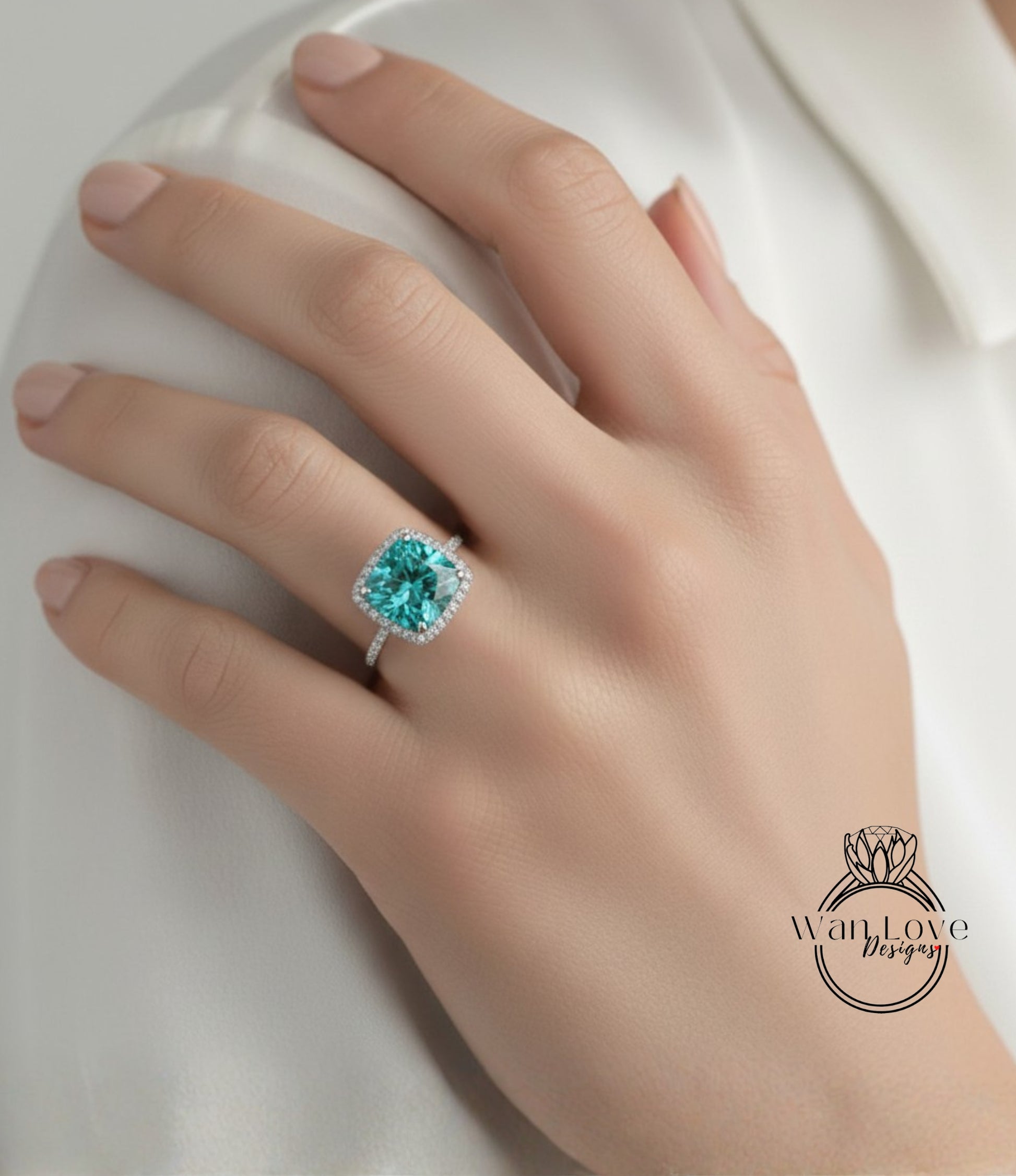 A close-up of a hand wearing a diamond ring with a large, vibrant green gemstone.