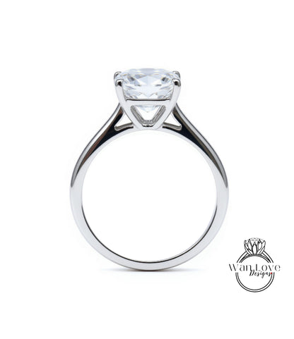 A silver engagement ring with a large, clear gemstone set in the center of the band.