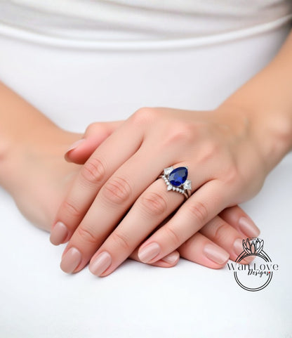 A close-up image of a person's hands wearing a ring with a blue gemstone.