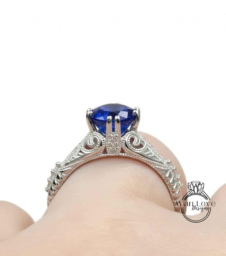 A close-up view of a silver engagement ring with a large blue gemstone, showcasing the intricate design and craftsmanship.