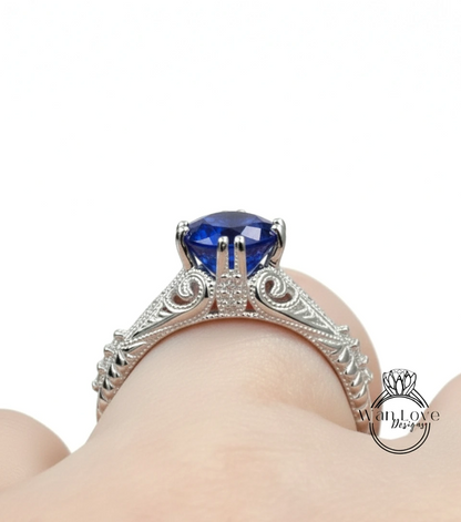 A close-up view of a silver engagement ring with a large blue gemstone, showcasing the intricate design and craftsmanship.