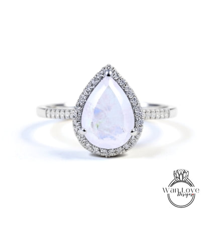 A diamond ring with a large, clear gemstone set in a halo of smaller diamonds.