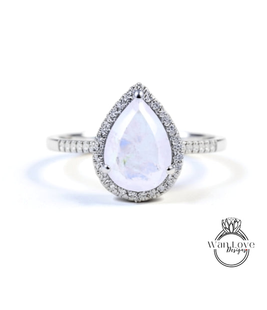 A diamond ring with a large, clear gemstone set in a halo of smaller diamonds.