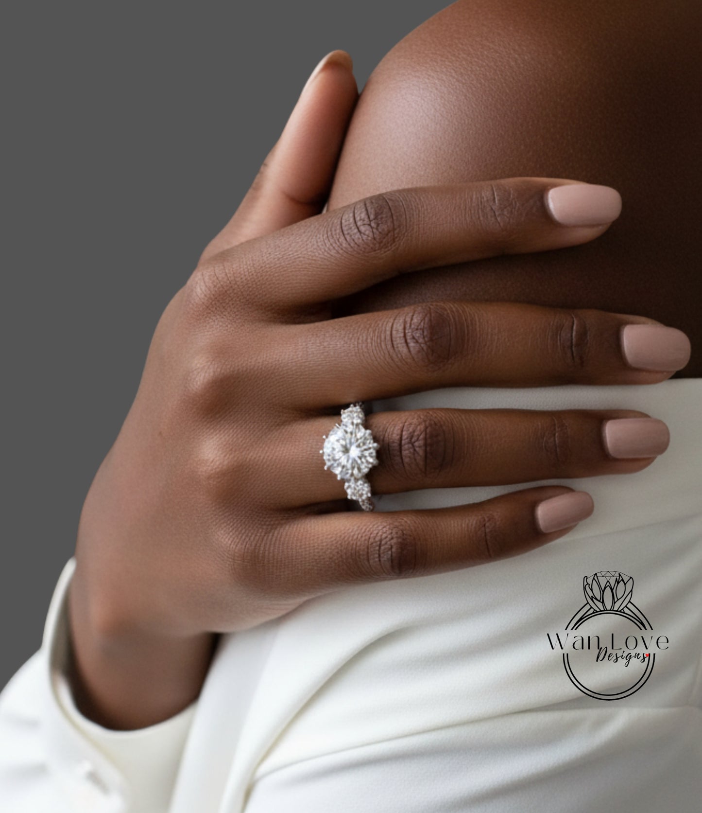 A close-up of a person's hand wearing a diamond engagement ring on the ring finger.