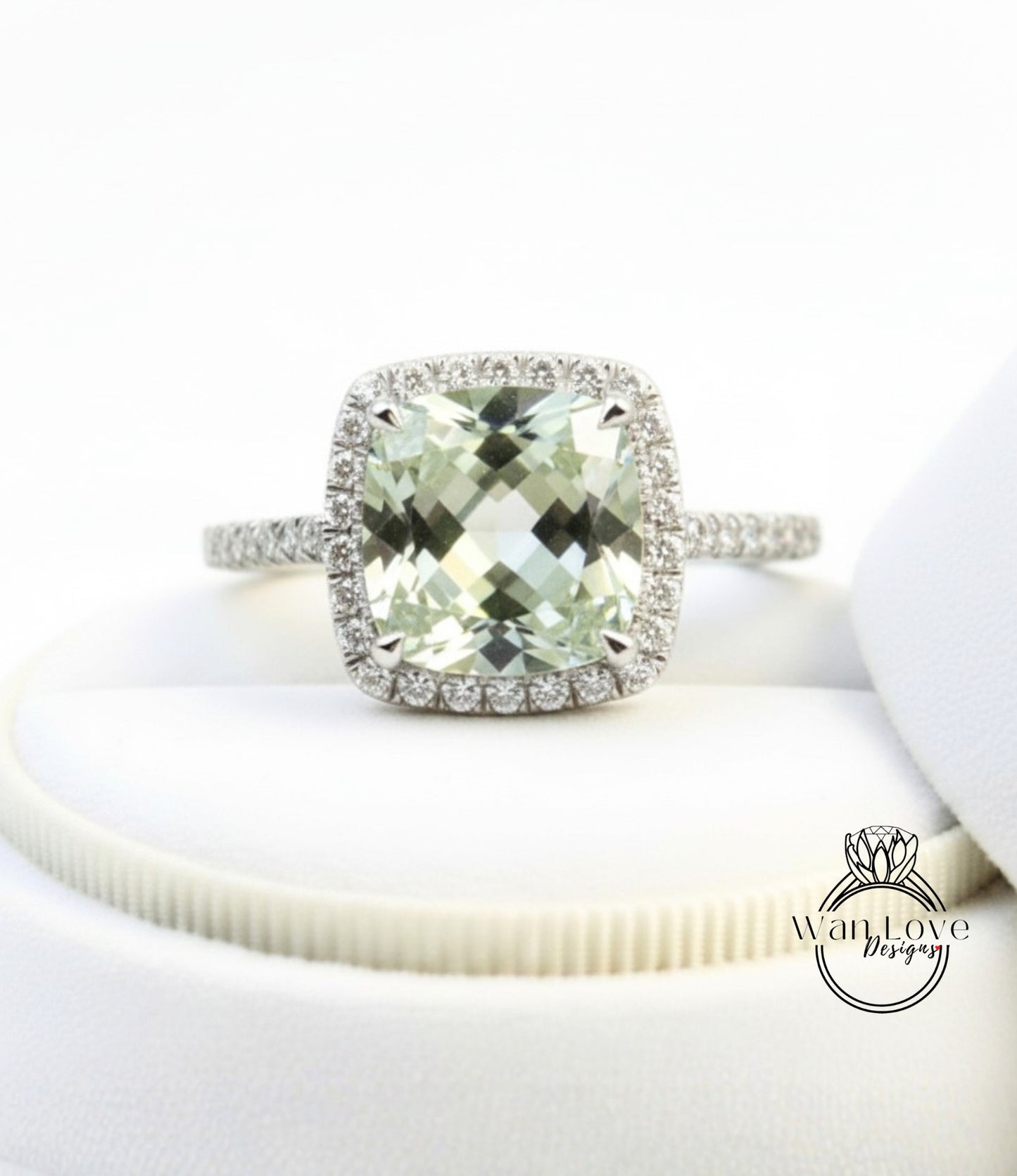 A diamond engagement ring with a large, square-cut green gemstone set in a halo of smaller diamonds.