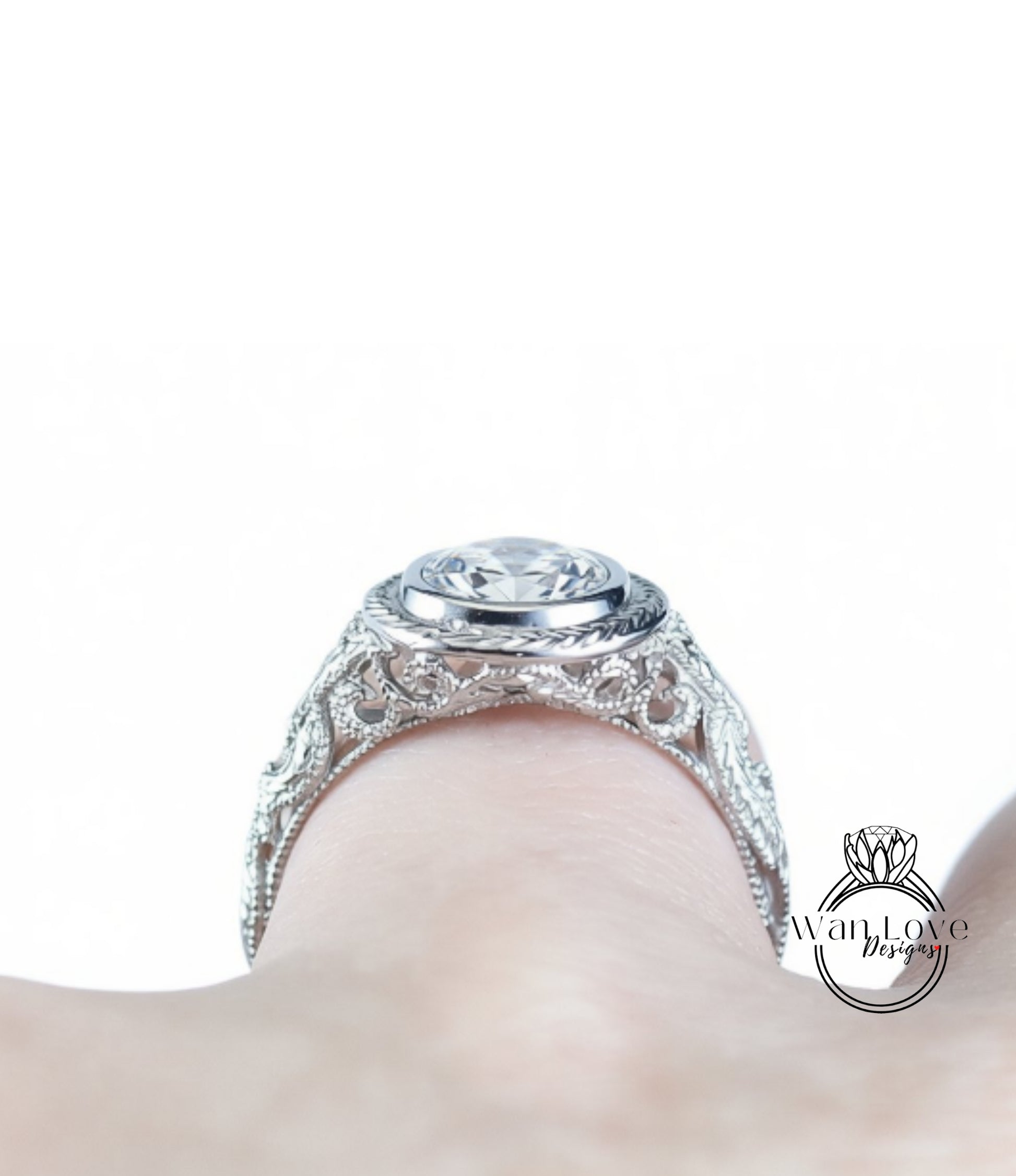A close-up view of a diamond engagement ring on a person's hand, showcasing the intricate design and sparkling gemstone.