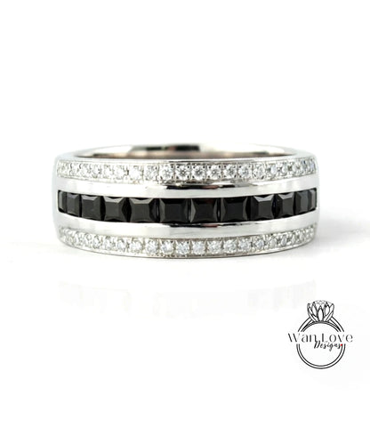 A silver ring with a row of black diamonds and a row of white diamonds along the band.