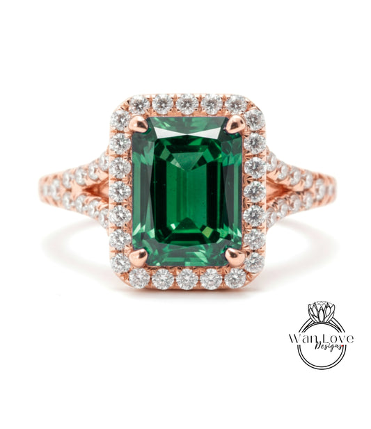 A stunning engagement ring with a large, rectangular green gemstone surrounded by a halo of smaller diamonds set in a rose gold band.