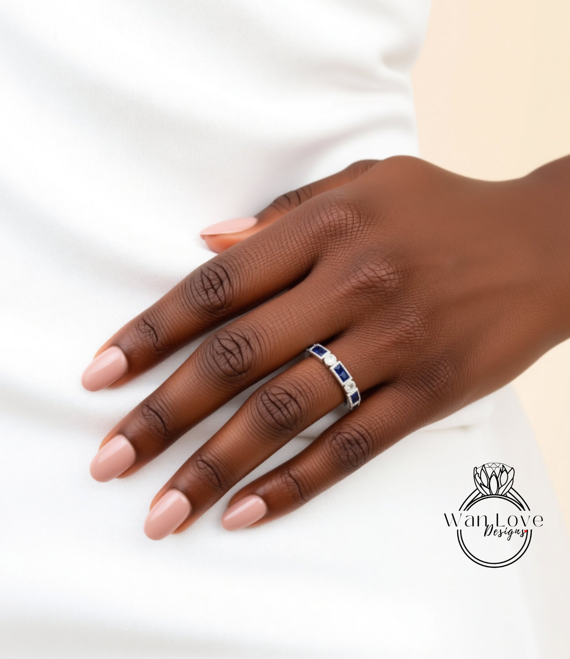 A close-up of a hand wearing a ring with blue and white stones.