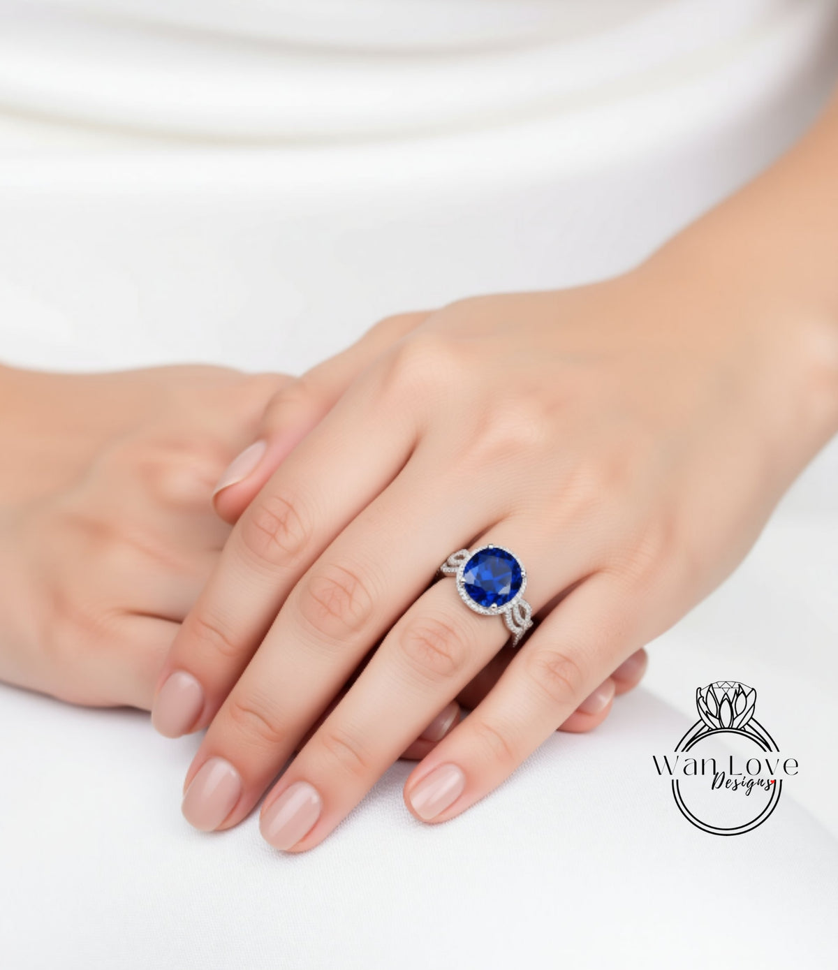A close-up of a person's hand wearing a ring with a large blue gemstone.