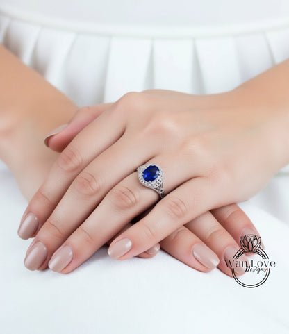 A close-up image of a person's hands wearing a ring with a large blue gemstone.