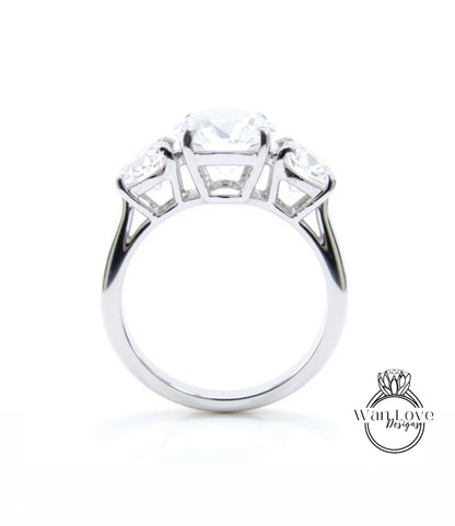 A silver engagement ring with a large central diamond surrounded by smaller diamonds on either side.
