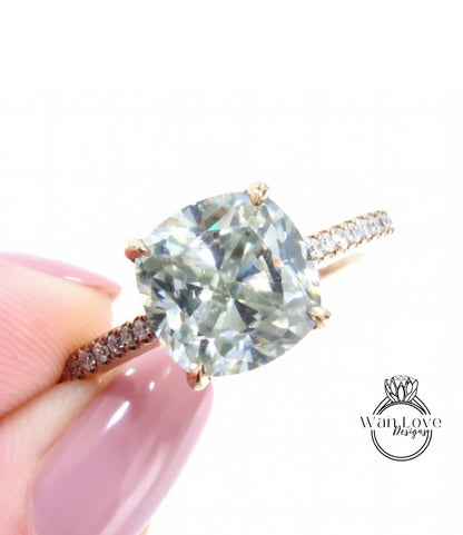 A close-up image of a person's hand holding a diamond engagement ring with a large, clear gemstone set in a gold band.