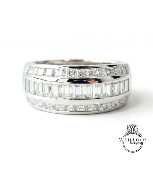 A silver ring with a row of diamonds set in it.