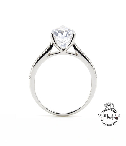 A silver engagement ring with a large, clear gemstone set in the center of the band.