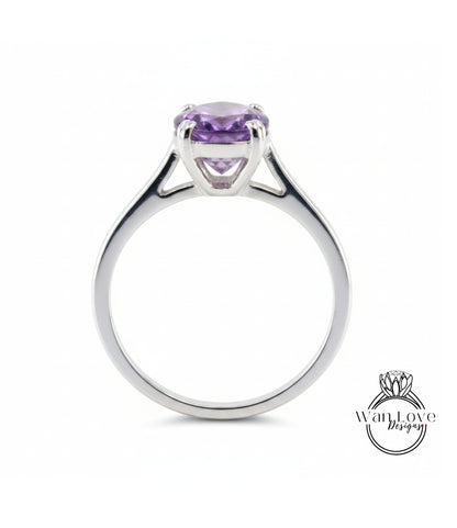 A silver ring with a large, purple gemstone set in the center.